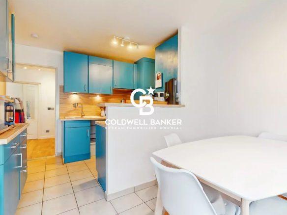 Modern kitchen in an apartment in Meudon with blue furniture and a white table.