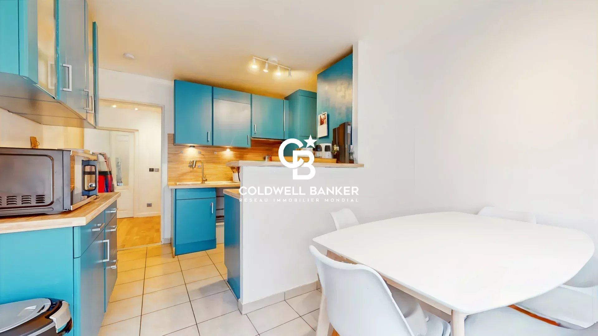 Kitchen of an apartment in Meudon Modern kitchen in an apartment in Meudon with blue furniture and a white table.