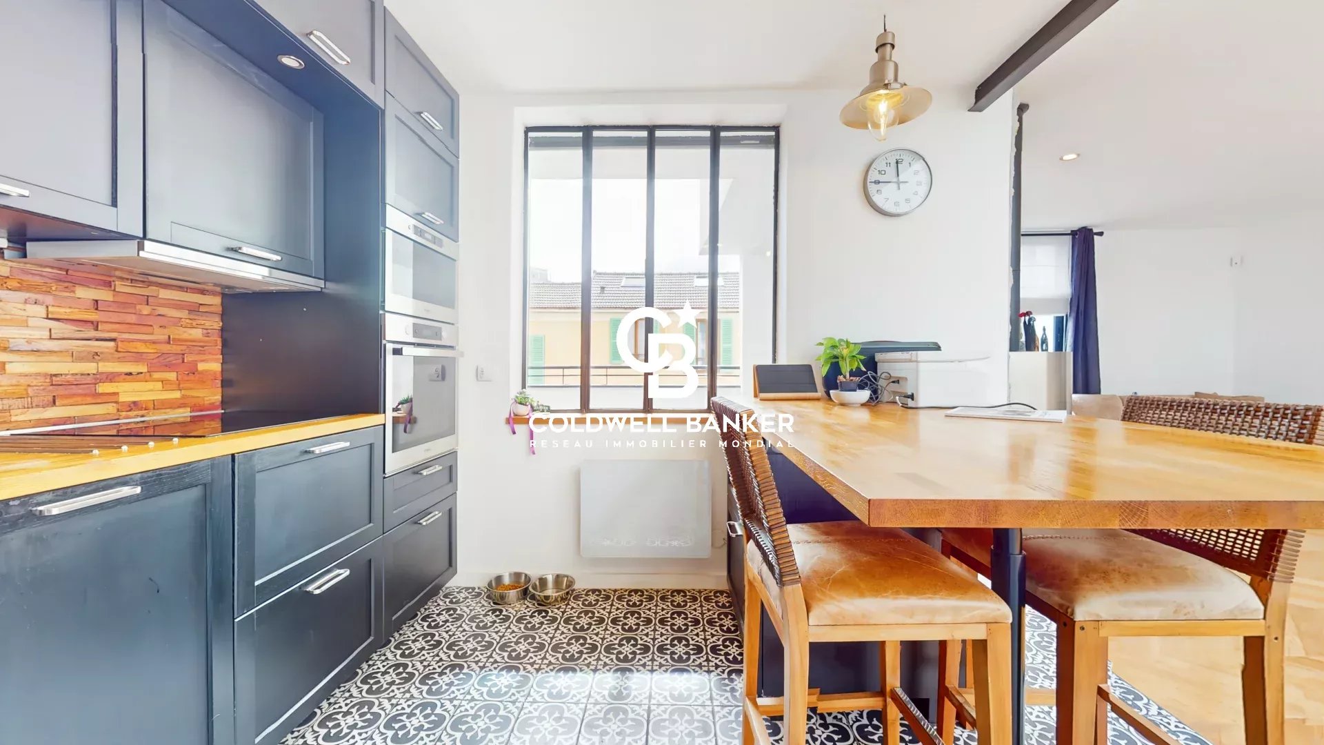 Cuisine moderne avec table en bois et carrelage décoratif dans une maison loft à Gentilly.