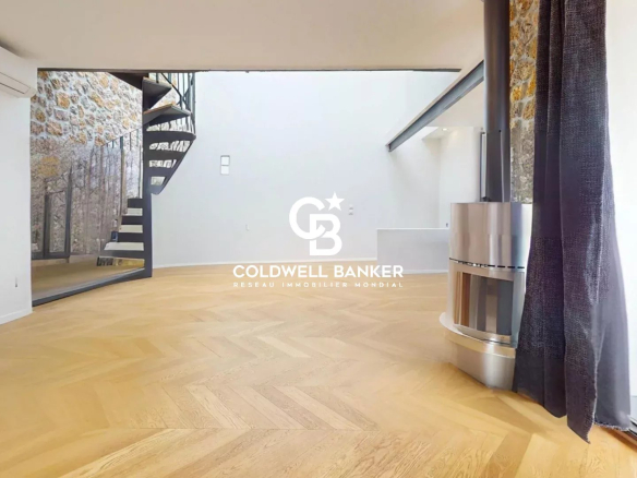 Intérieur d'une maison loft industriel avec terrasse à Gentilly, présentant un séjour spacieux sous verrière.