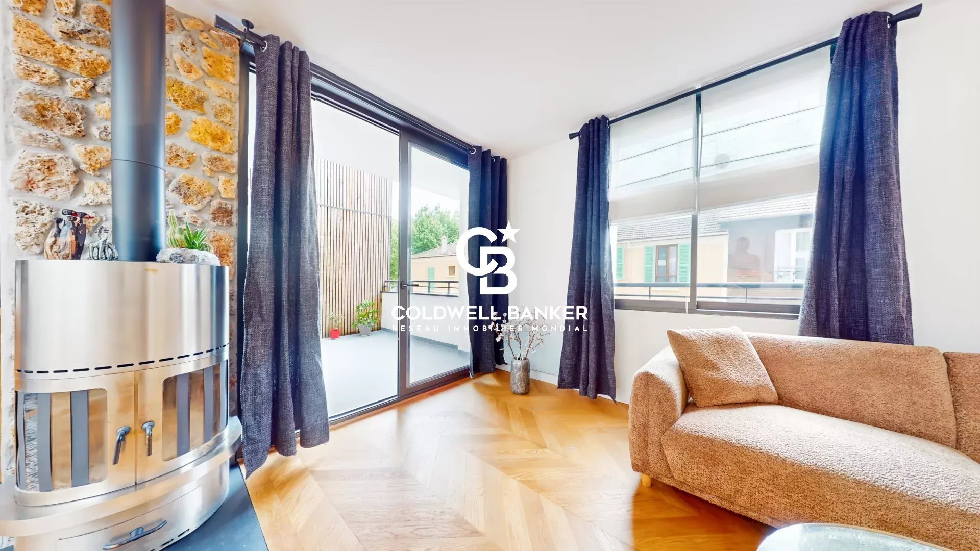 Intérieur d'une maison loft industriel avec terrasse à Gentilly, fenêtres et salon lumineux.