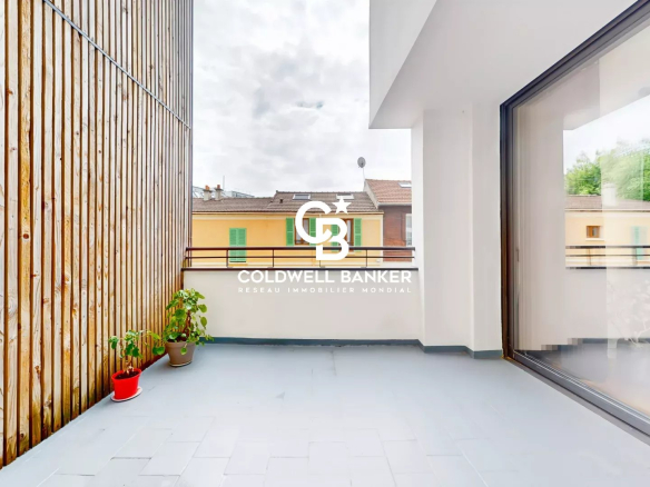 Terrasse d'une maison loft industriel à Gentilly, avec vue sur des bâtiments voisins.