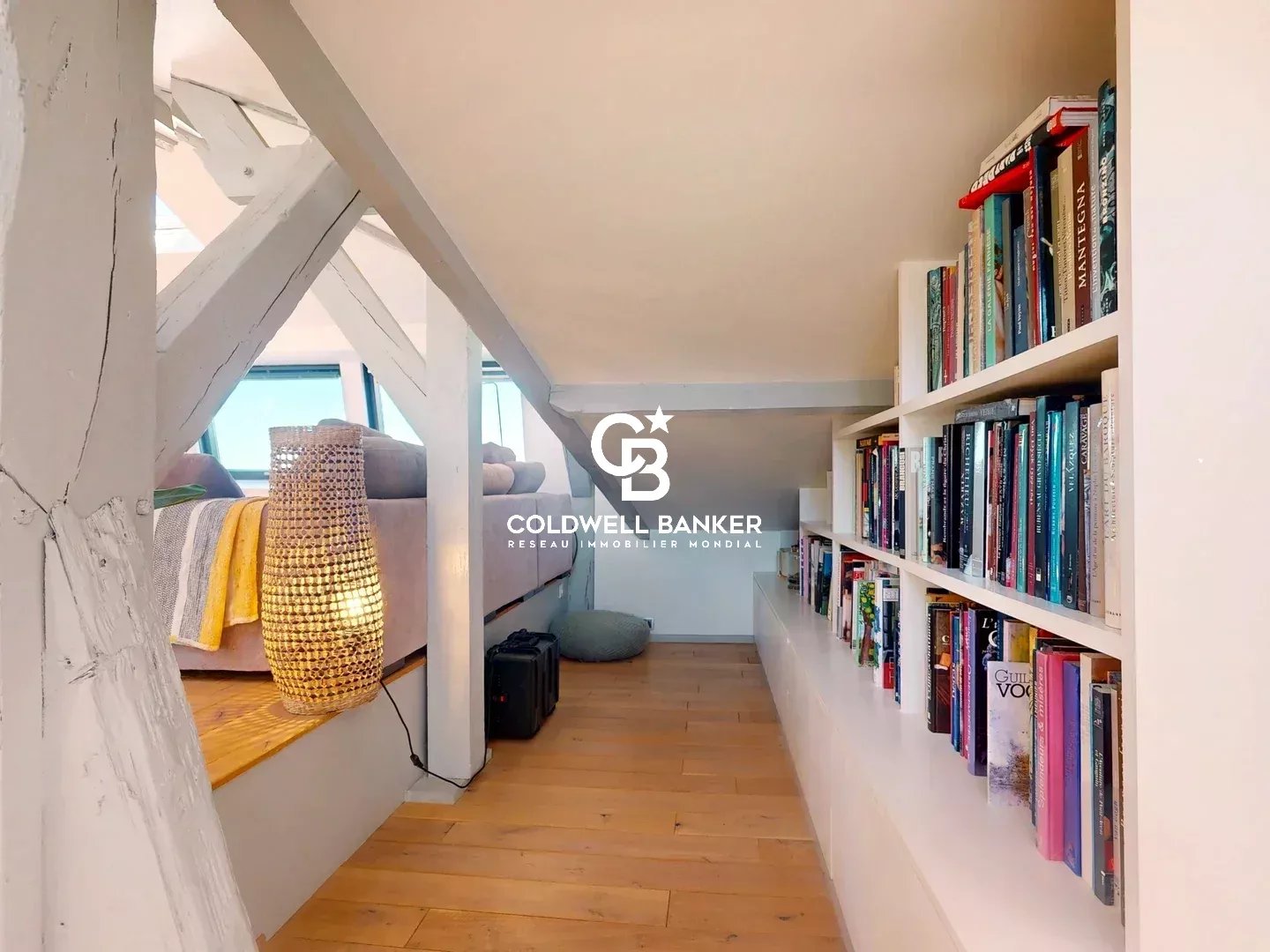 Intérieur d'un appartement avec étagères de livres et espace lumineux au Château des Montalets à Meudon.