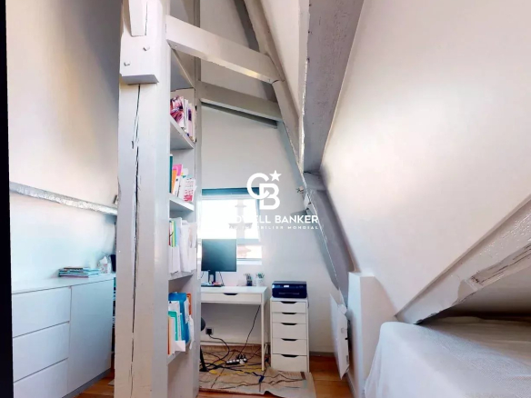 Intérieur d'un appartement sous les combles avec un bureau et des étagères, Château des Montalets à Meudon.