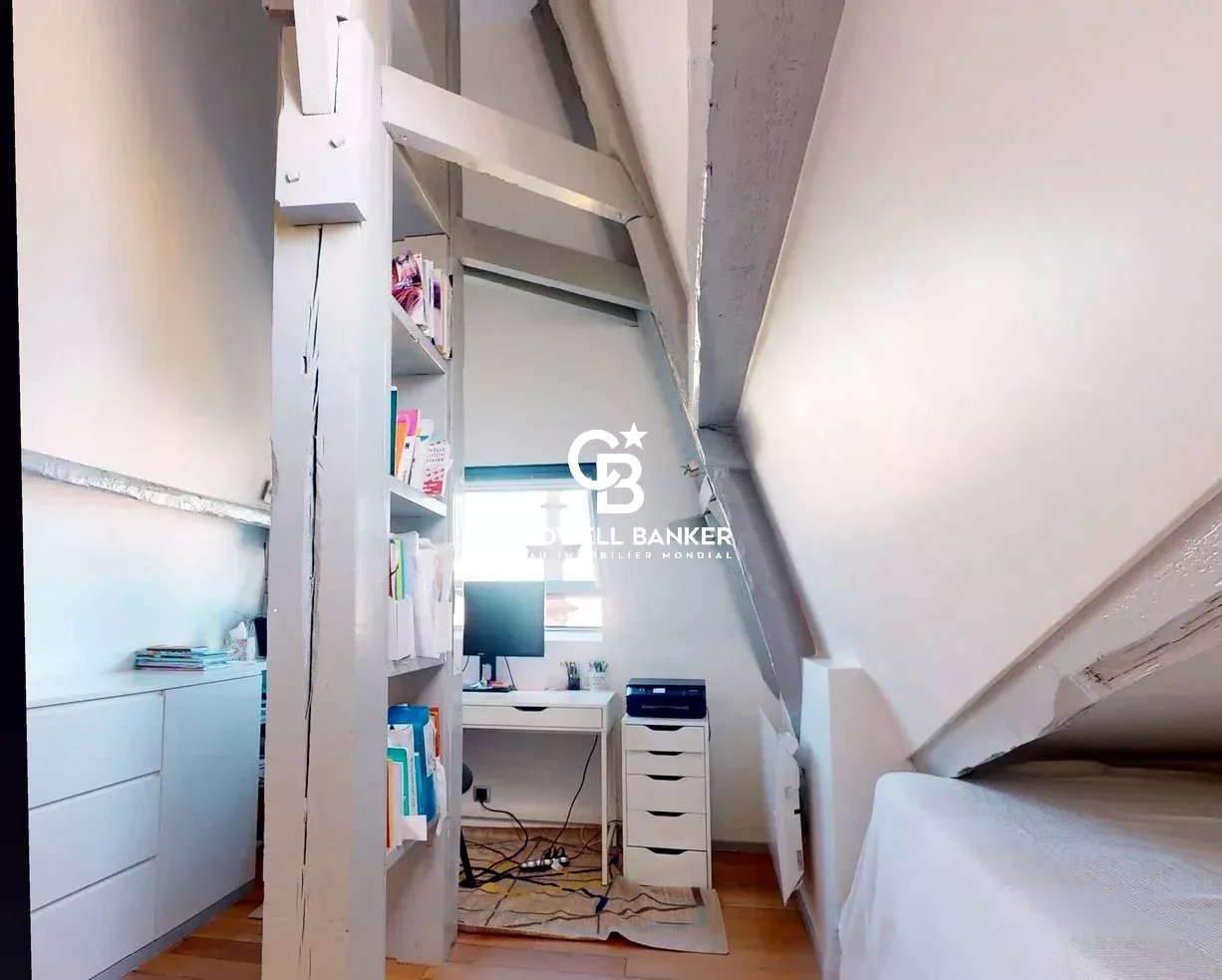 Intérieur d'un appartement sous les combles avec un bureau et des étagères, Château des Montalets à Meudon.