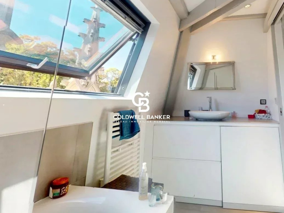Salle de bain moderne avec fenêtre de toit dans un appartement lumineux.