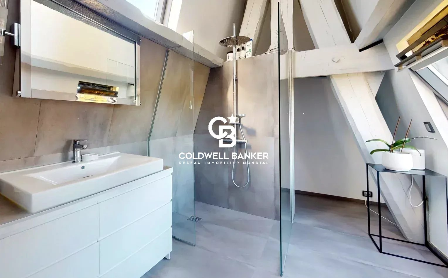 Salle de bain d’un appartement au Château des Montalets Salle de bain moderne avec douche à l'italienne et lavabo dans un appartement sous les combles.