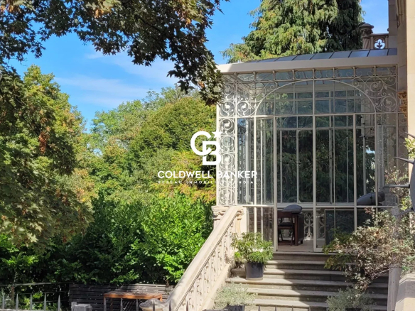 Entrée du Château des Montalets avec une véranda en verre et des jardins verdoyants.
