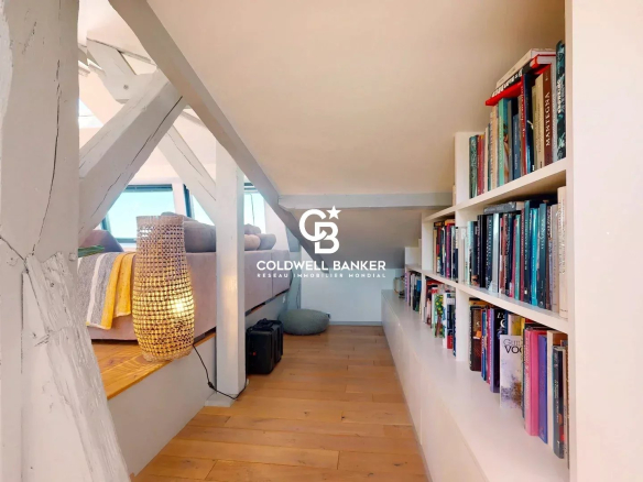 Intérieur d'un appartement lumineux avec étagères et livres, au Château des Montalets à Boulogne-Billancourt.