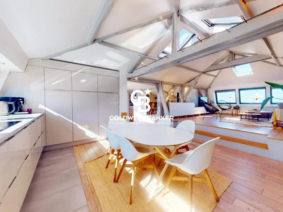 Intérieur d'un appartement lumineux avec cuisine ouverte et salle à manger, au Château des Montalets.
