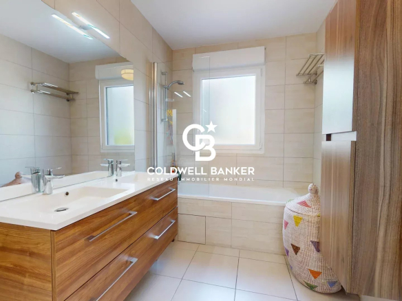 Salle de bain moderne avec meuble en bois et miroir, fenêtres laissant entrer la lumière