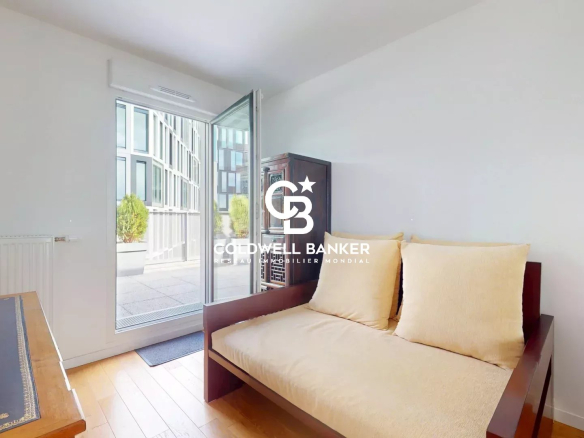 Intérieur d'un appartement lumineux avec un canapé et une porte donnant sur une terrasse.