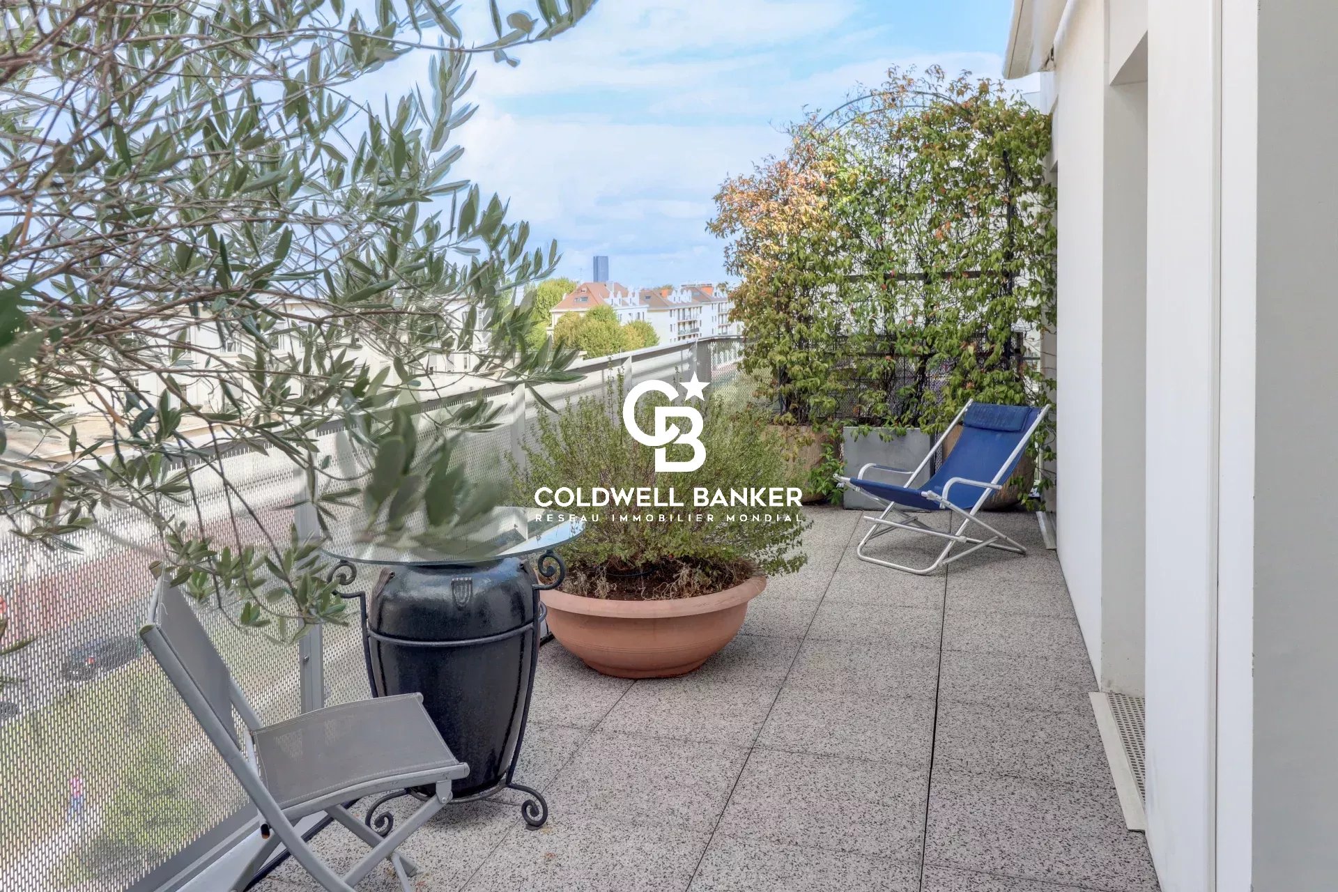 Terrasse d'un appartement au 5ème étage à Montrouge, avec des chaises et des plantes.