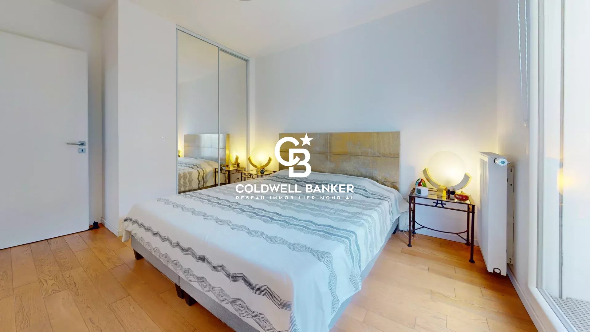 Chambre d'un appartement lumineux avec lit et décor moderne.