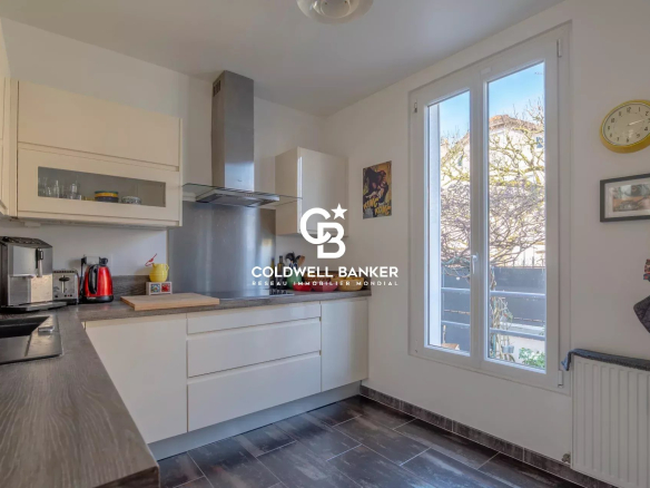 Modern kitchen in a house with white furniture and a wooden worktop.