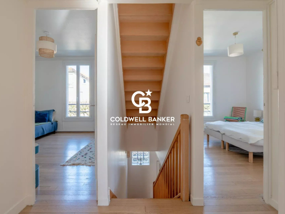Interior of a house with a wooden staircase and bright rooms.