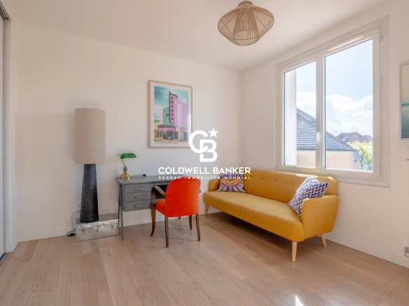 Interior of a modern house with a yellow sofa and a desk, natural light in Joinville-le-Pont.
