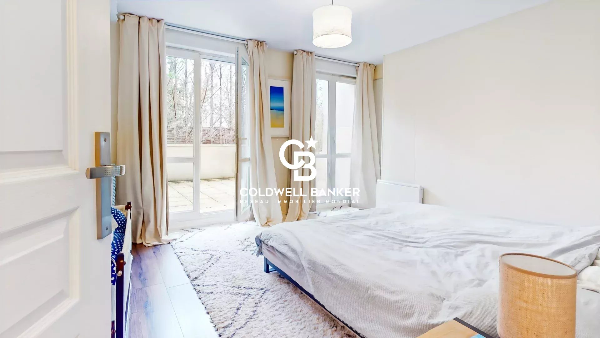 Chambre lumineuse d'un appartement avec accès à une terrasse.