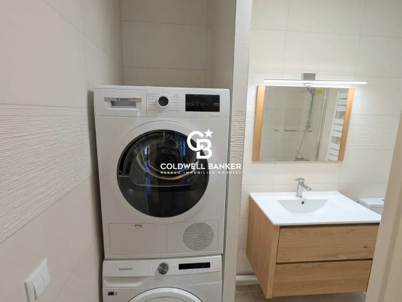 Lave-linge et sèche-linge empilés dans une salle de bain moderne.