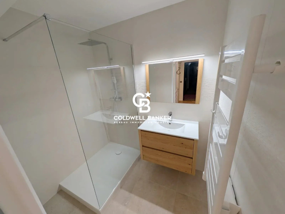 Salle de bain moderne avec douche à l'italienne et meuble en bois.