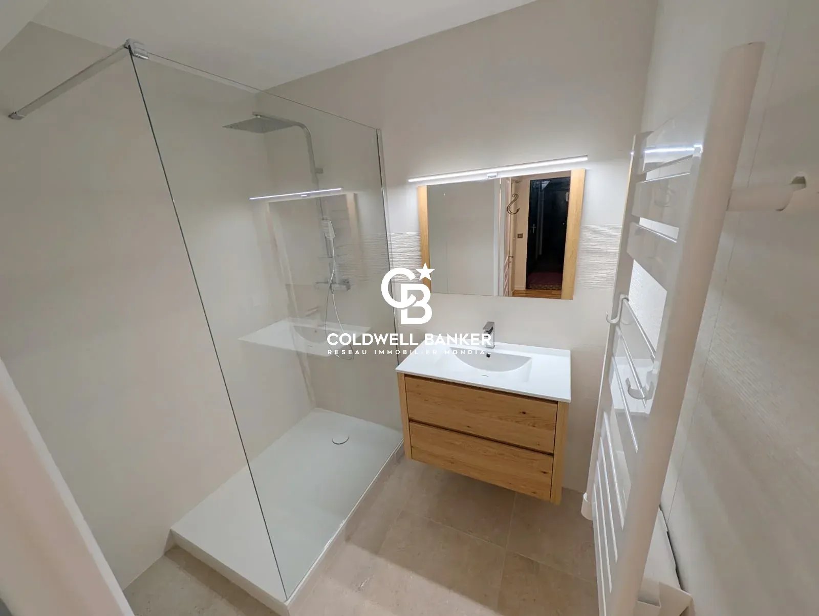 Salle de bain moderne avec douche à l'italienne et meuble en bois.