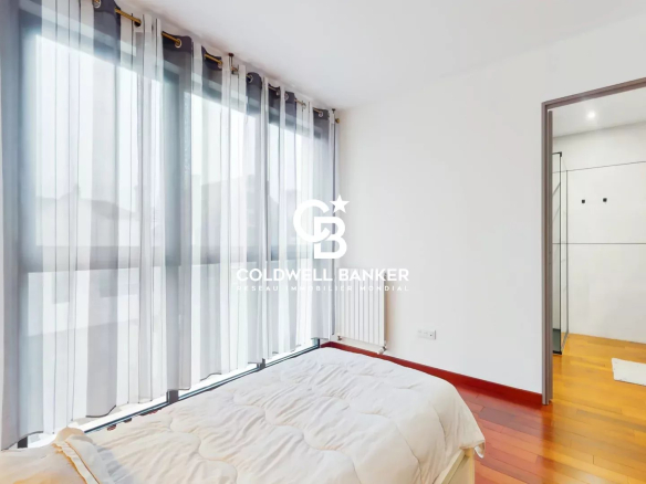 Bright bedroom in a contemporary house in Sceaux with windows and wooden parquet flooring.