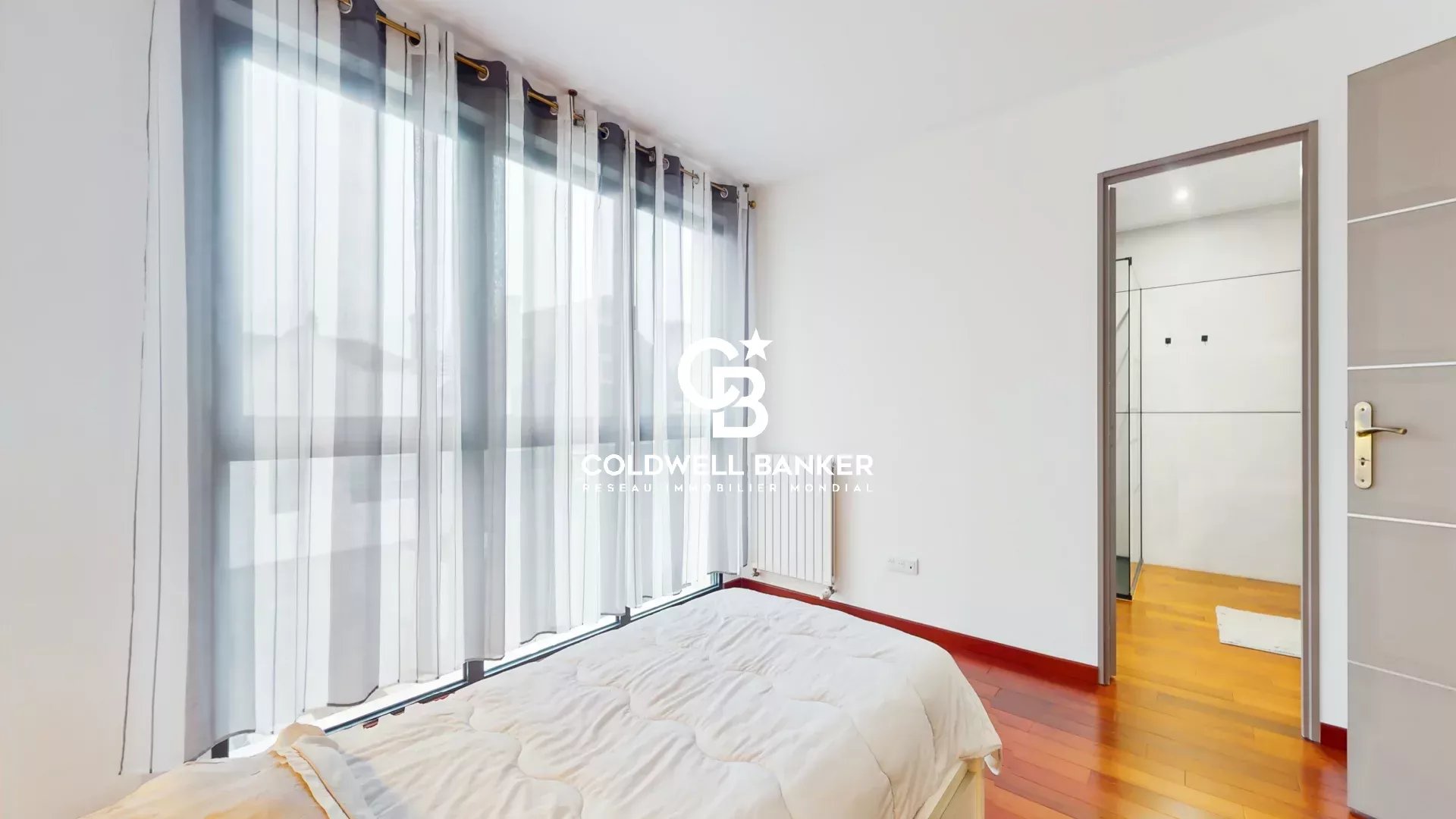 Contemporary bedroom in Sceaux Bright bedroom in a contemporary house in Sceaux with windows and wooden parquet flooring.