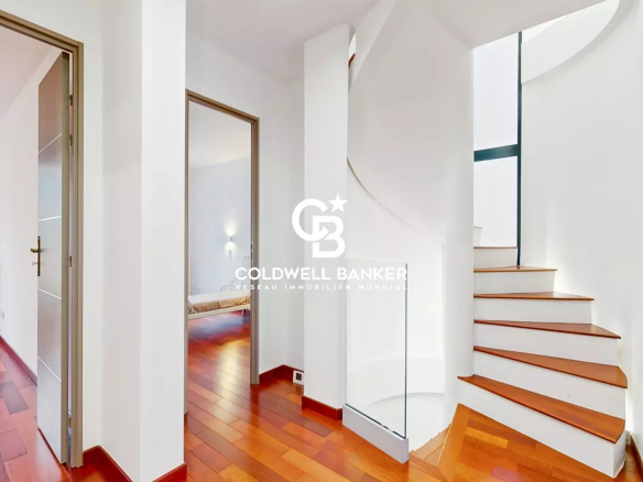 Interior of a contemporary house in Sceaux with a wooden staircase and white walls.