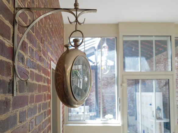 Pendule ancienne accrochée à un mur de briques dans une maison de Suresnes.