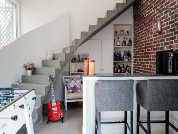 Intérieur d'une maison à Suresnes avec un escalier moderne et un bar.