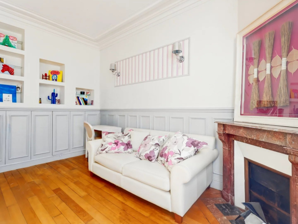 Intérieur d'une maison à Suresnes avec un salon lumineux et une cheminée en marbre.