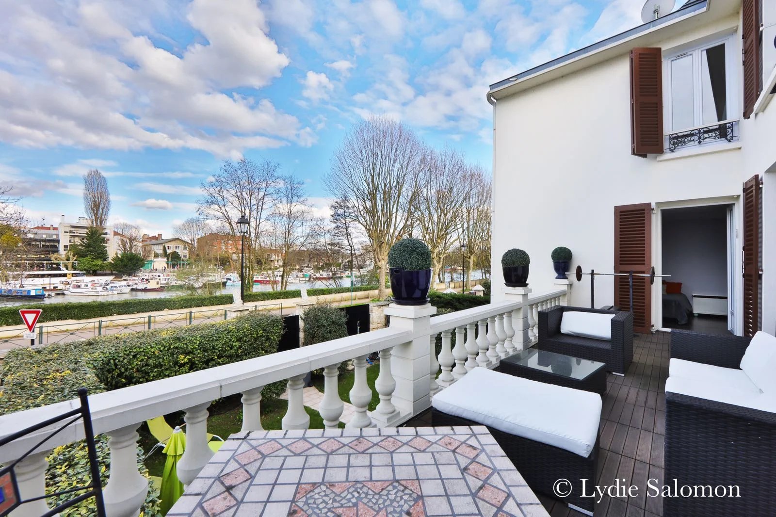 Terrasse avec vue sur la Marne Terrasse d'une maison avec vue sur la Marne à Joinville-le-Pont, mobilier de jardin en extérieur.