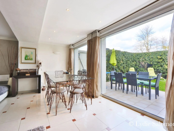 Intérieur d'une maison rénovée avec salle à manger et accès à un jardin.