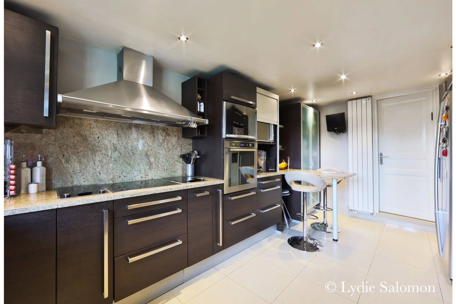 Cuisine moderne d’une maison à Joinville-le-Pont Cuisine moderne et équipée d'une maison rénovée, avec plans de travail en granit et bar à manger.