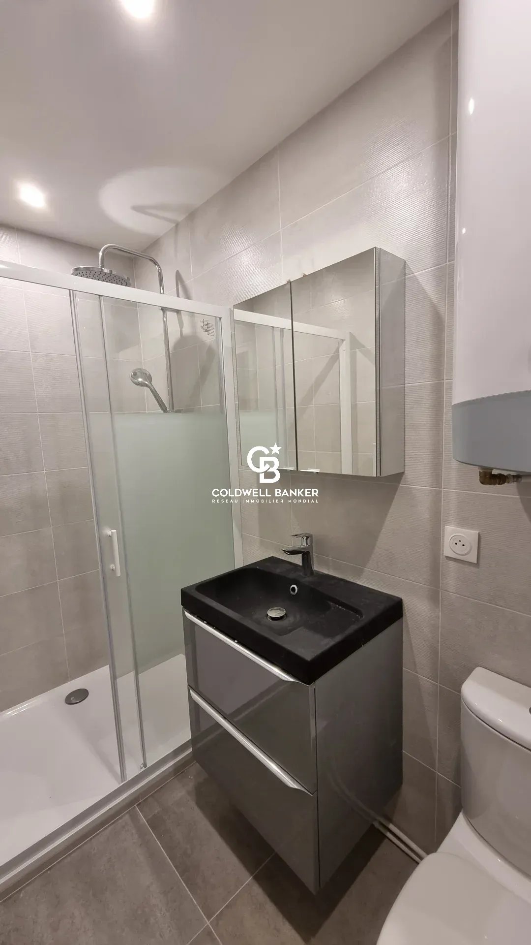 Salle de bain d’un appartement rénové Salle de bain moderne avec douche, lavabo et toilettes dans un appartement rénové.