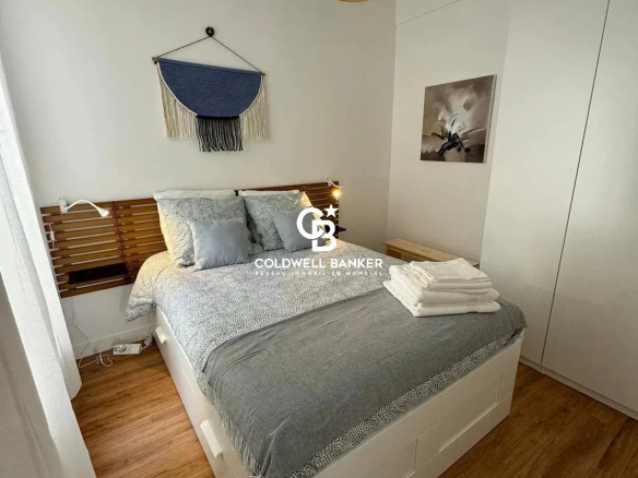 Chambre d'un appartement rénové avec lit double et décoration moderne.