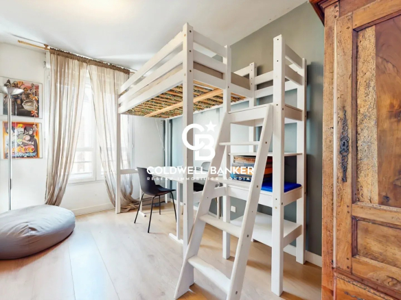 Chambre d'un appartement à Montrouge avec lit superposé et mobilier en bois.