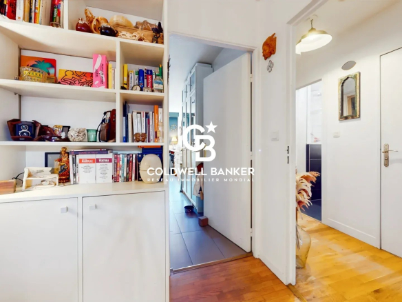 Intérieur d'un appartement avec un couloir et des étagères décoratives.