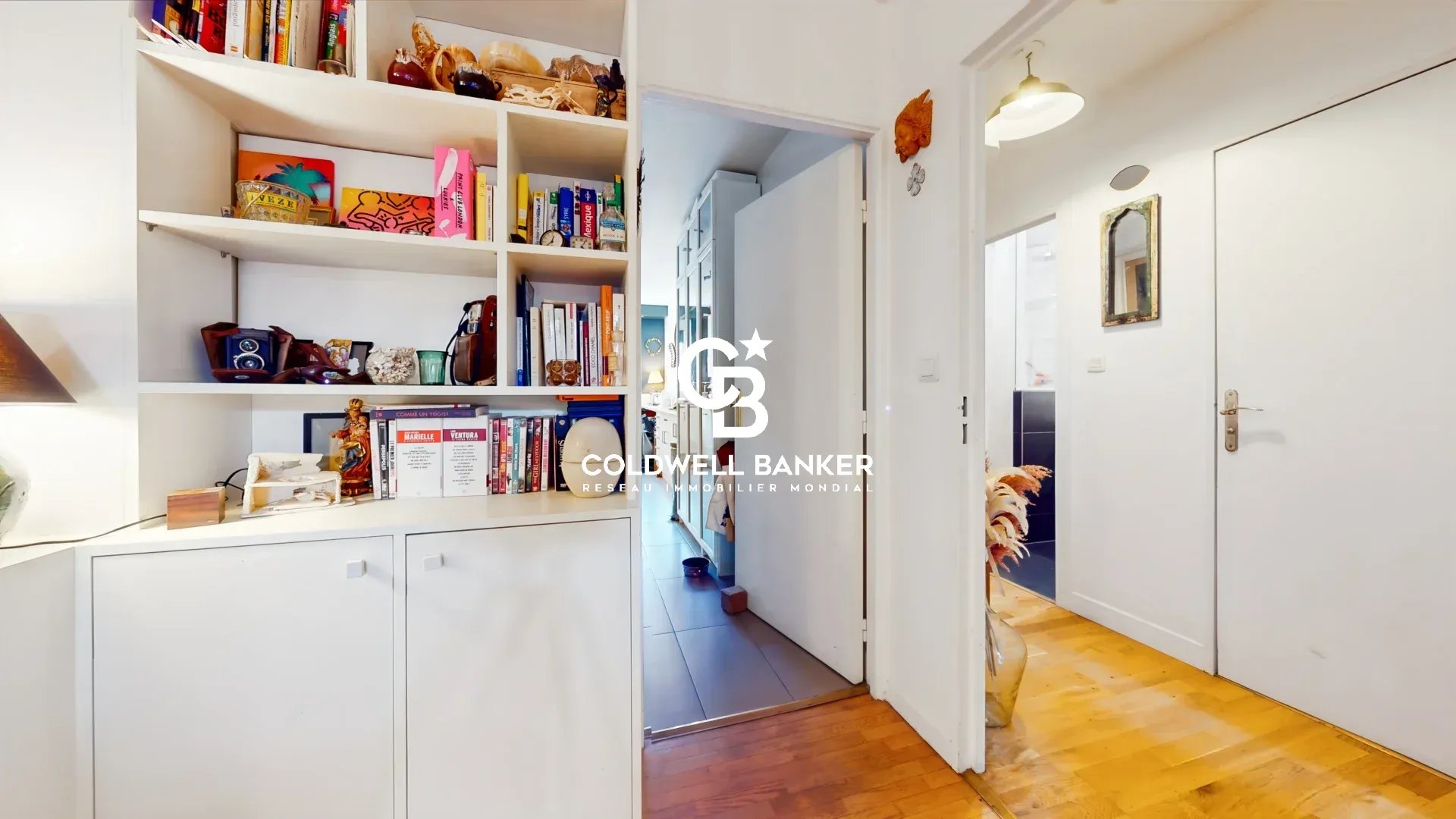 Intérieur d’un appartement à Montrouge Intérieur d'un appartement avec un couloir et des étagères décoratives.