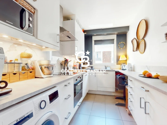 Cuisine moderne et fonctionnelle d'un appartement à Montrouge, avec électroménagers intégrés.