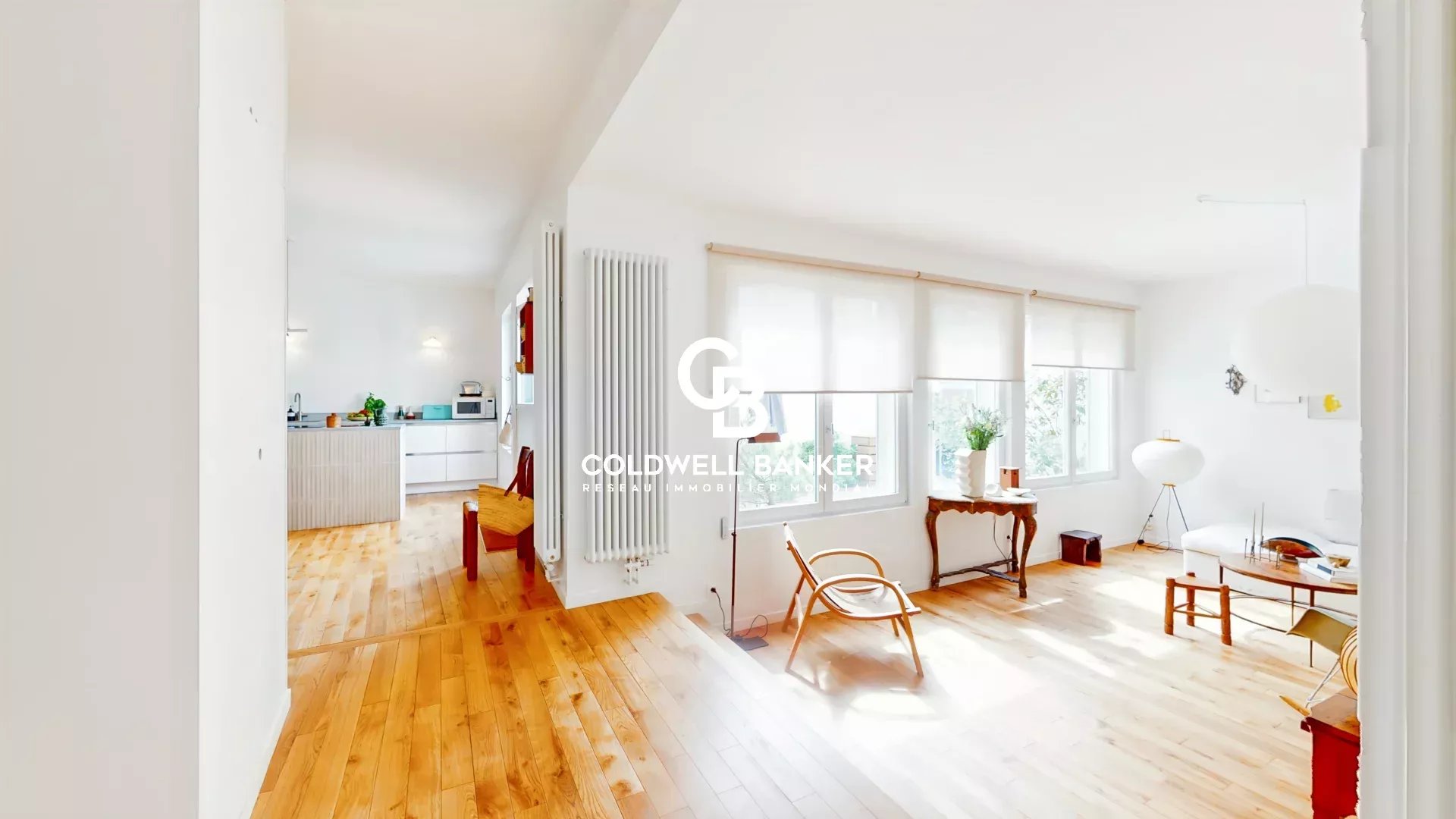 Intérieur d'une maison lumineuse avec parquet en bois et mobilier moderne.