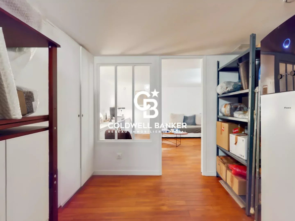 Intérieur d'une maison avec des étagères et un espace de vie lumineux.