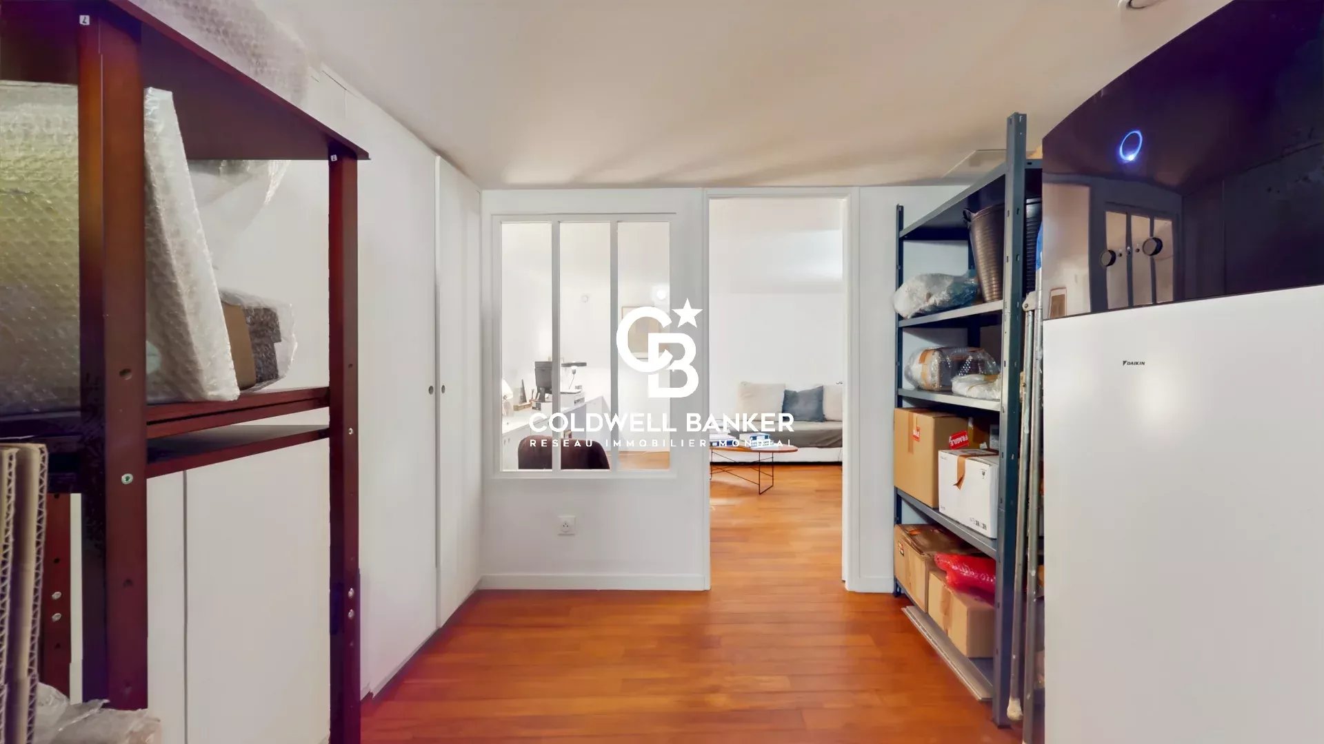 Intérieur d'une maison avec des étagères et un espace de vie lumineux.