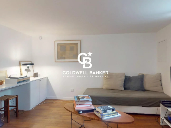 Intérieur d'une maison avec un salon lumineux et un canapé, décoré de manière moderne.