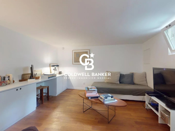Intérieur d'une maison à Malakoff avec un salon lumineux et un canapé.