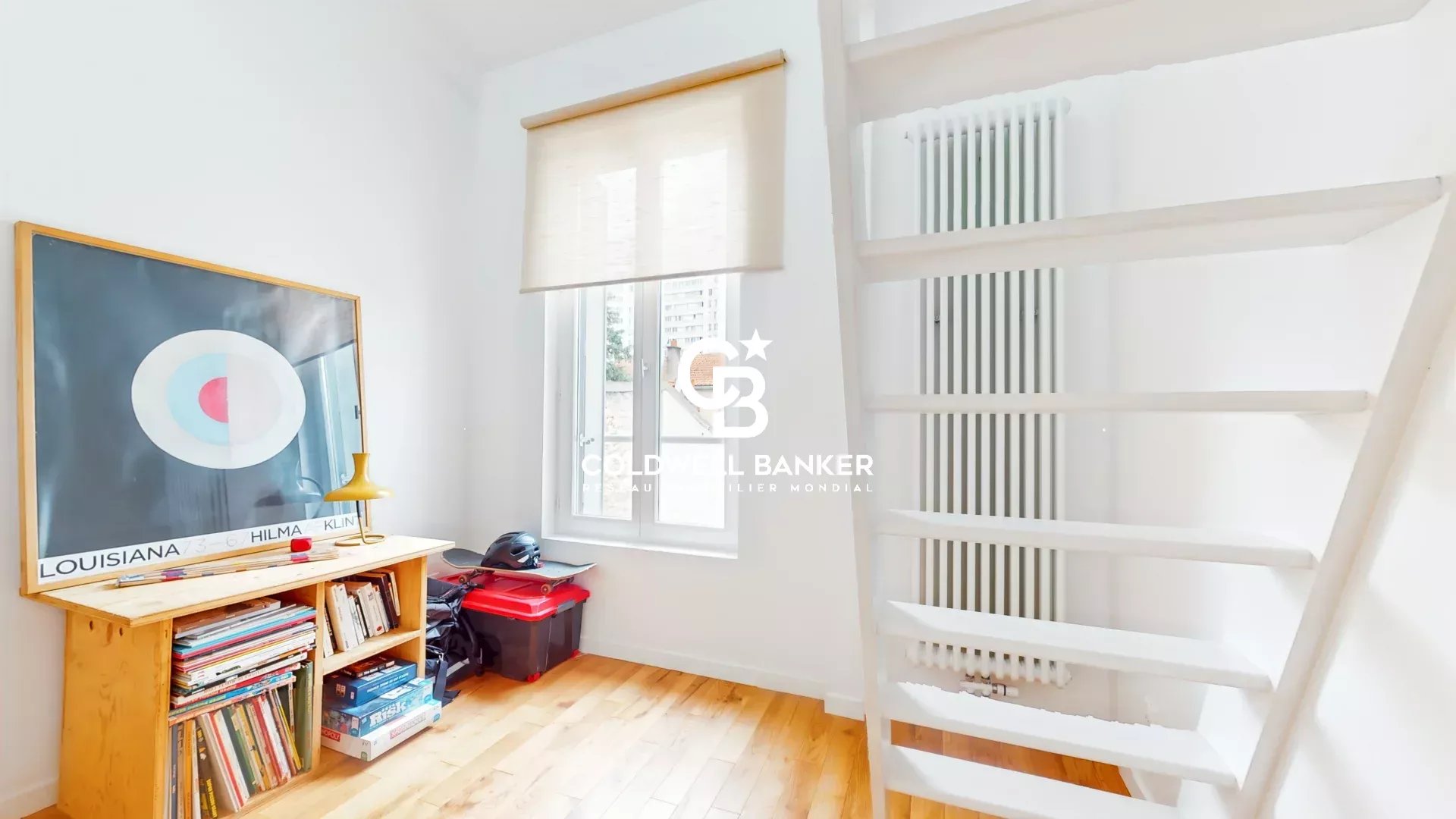 Intérieur d’une maison à Malakoff Intérieur d'une maison à Malakoff avec un escalier blanc et une étagère remplie de livres.