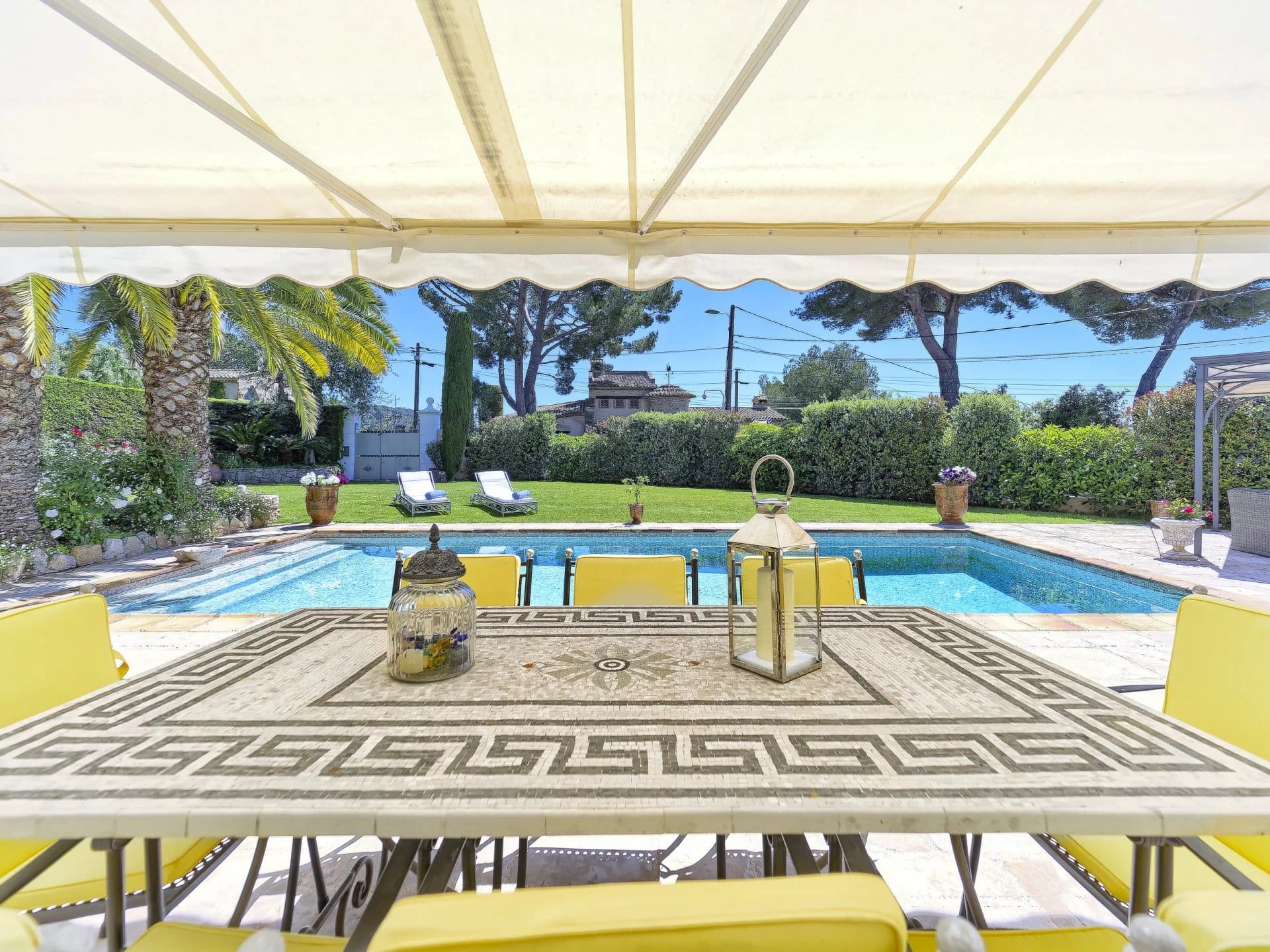 Terrace with table and chairs, swimming pool and wooded garden in Le Cannet.
