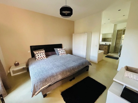 Chambre principale d'une villa à Mougins avec lit double et salle de bains attenante.