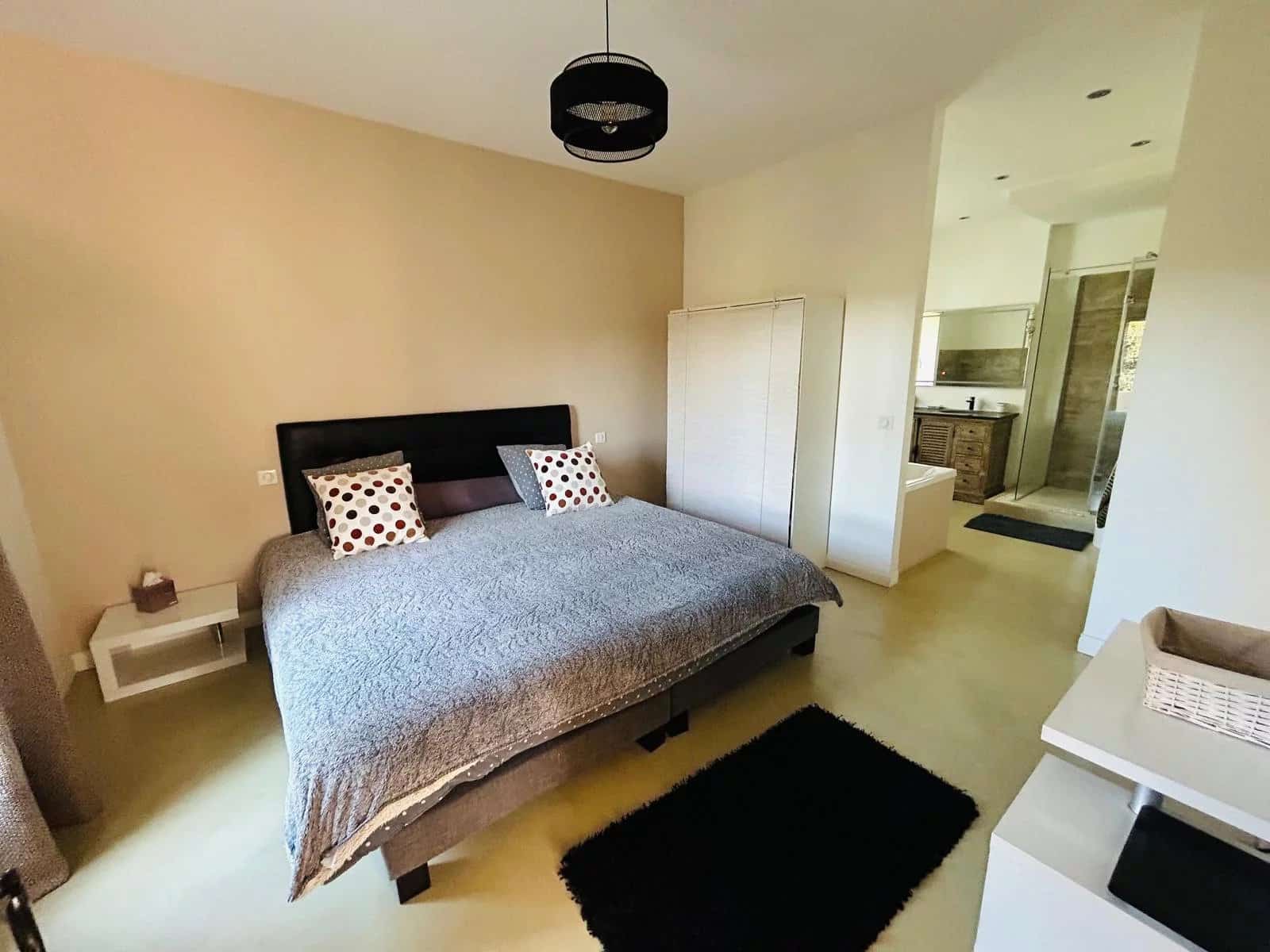 Chambre principale d'une villa à Mougins avec lit double et salle de bains attenante.