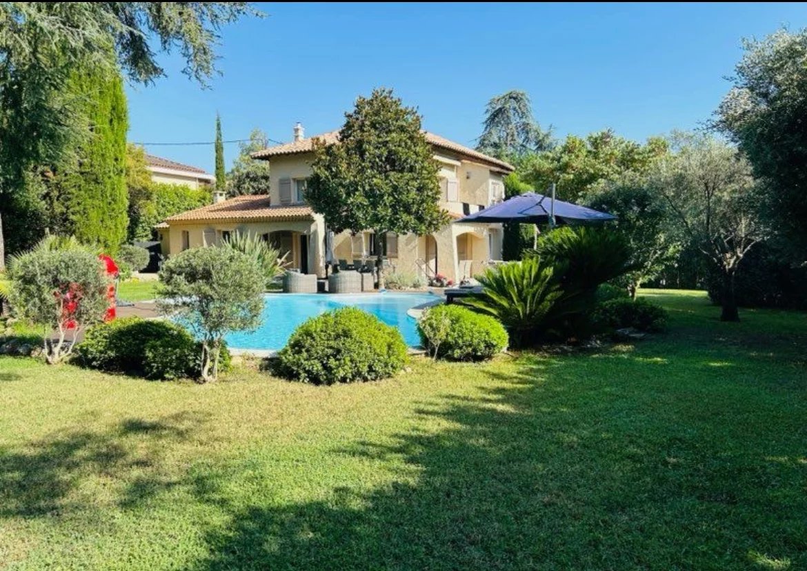 Villa avec piscine et jardin à Mougins, entourée d'arbres et de verdure.